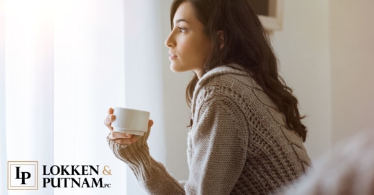 woman in sweater holding mug thinking