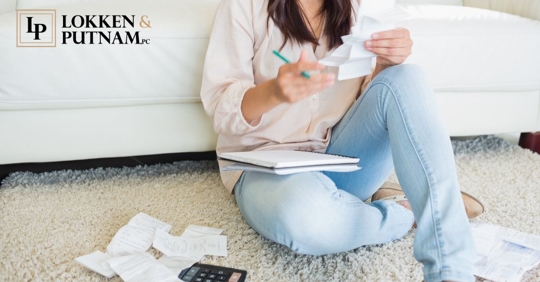 woman on the floor with papers, a calculator, and a notebook