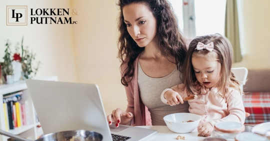 mom on computer with daughter sitting on her lap